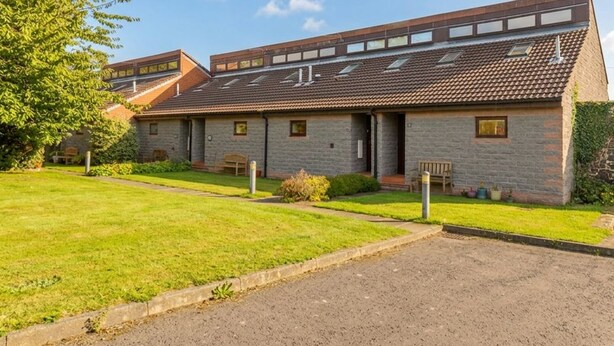A building with a flat roof, multiple windows, and a paved driveway. - Links View (Alnwick)