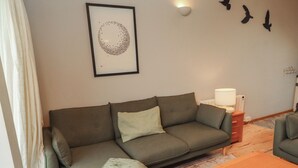A living room with a sofa, a coffee table, and a framed artwork on the wall. - Links View (Alnwick)