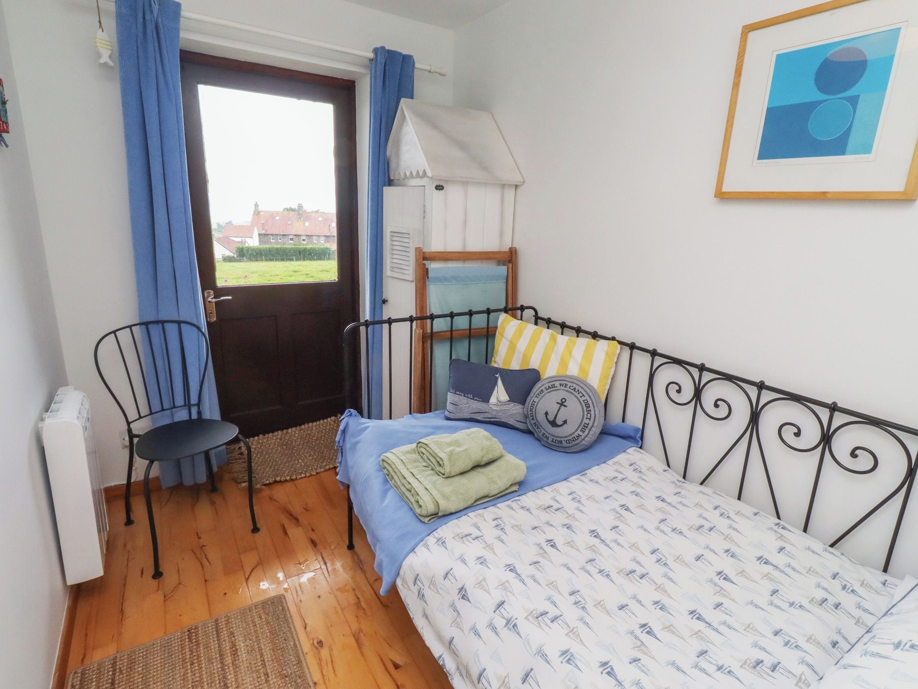 Een slaapkamer met een bed, een stoel, een raam en een deur.