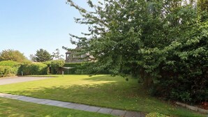 A well-maintained lawn with a pathway leading to a house. - Links View (Alnwick)