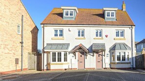 A two-story house with a tiled roof, a front porch, and a garage. - Coast View (Chathill)