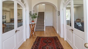 A hallway with white doors, a staircase, and a wooden floor. - The Lookout (Alnwick)