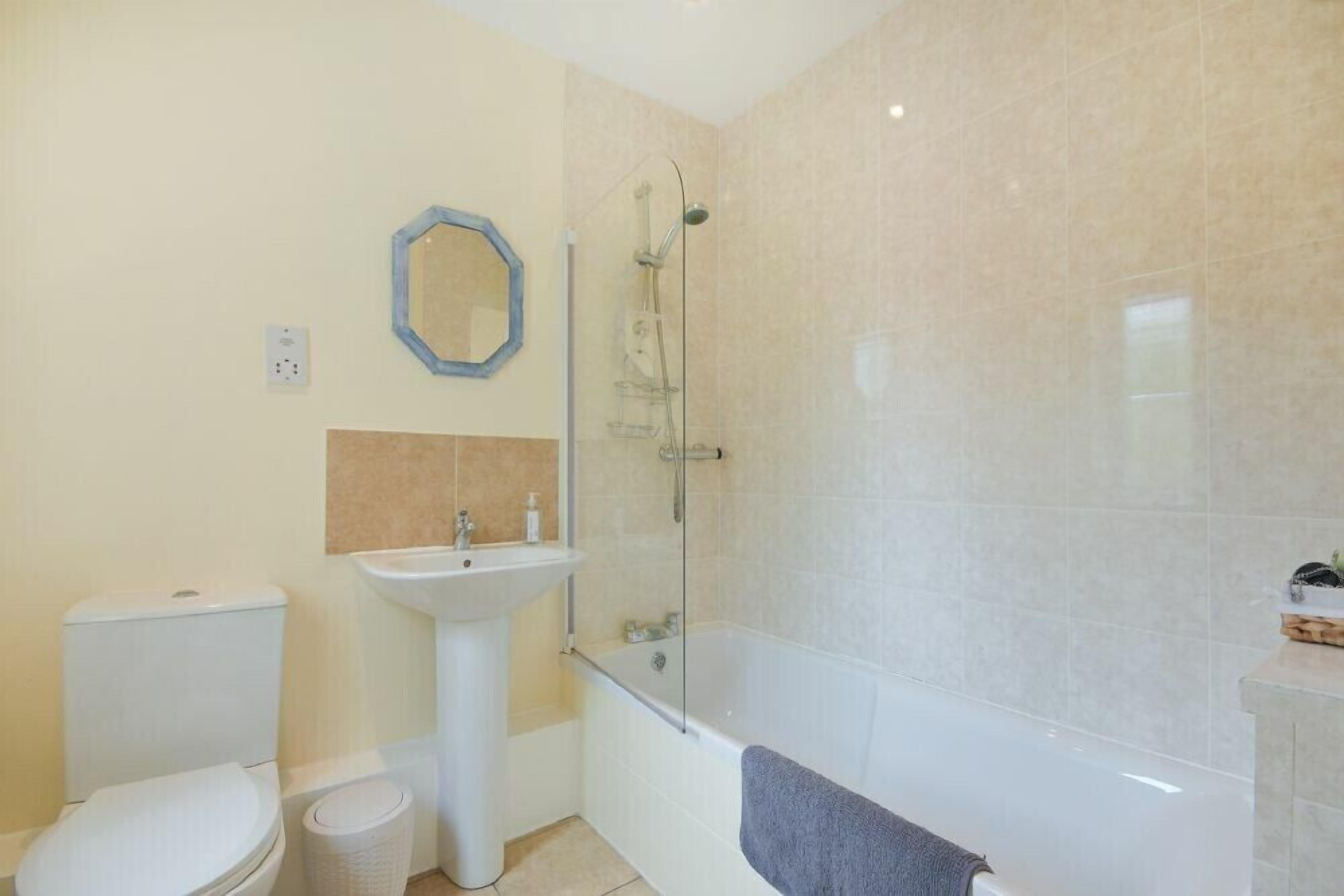 A bathroom with a toilet, sink, and bathtub.