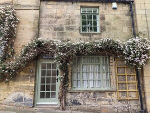 A stone building with a green door, a window with white curtains, and a sign reading "Book House". - The Book House (Morpeth)