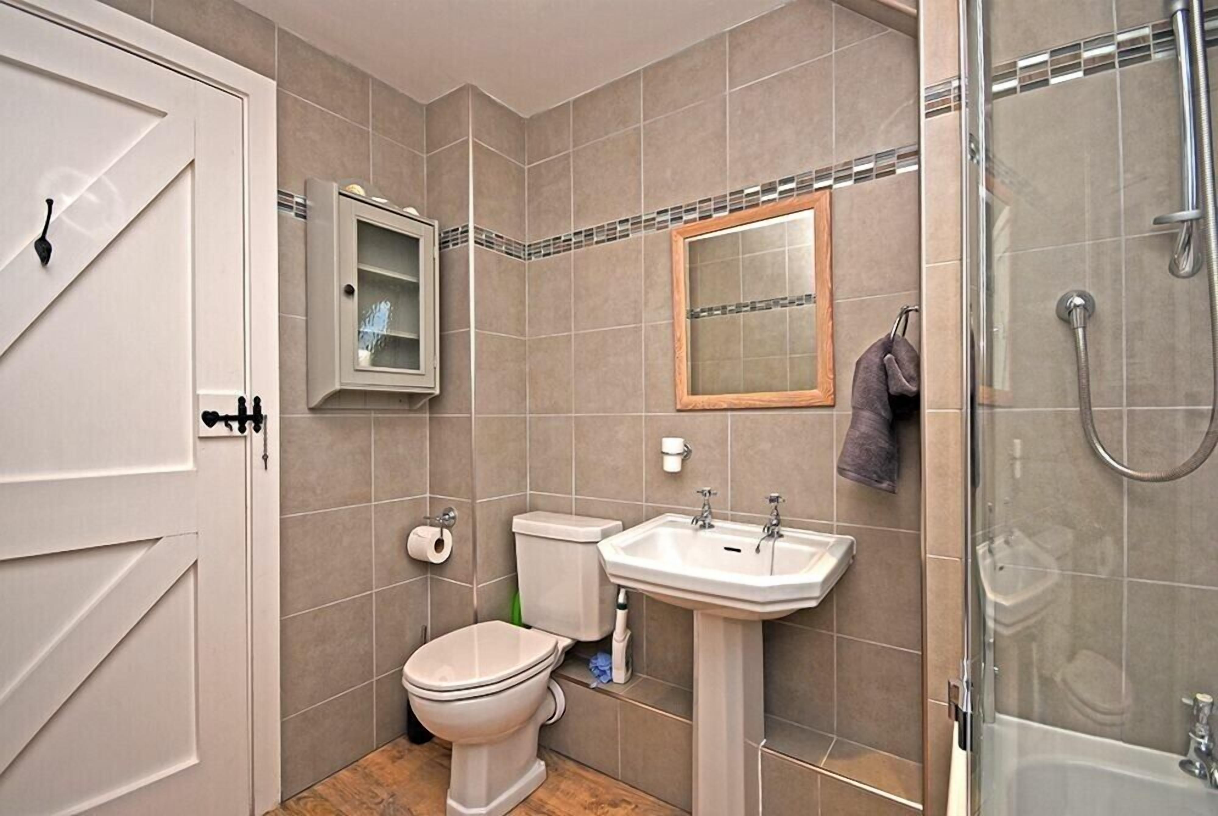 A bathroom with a toilet, sink, and shower.