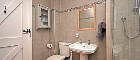 A bathroom with a toilet, sink, and shower.