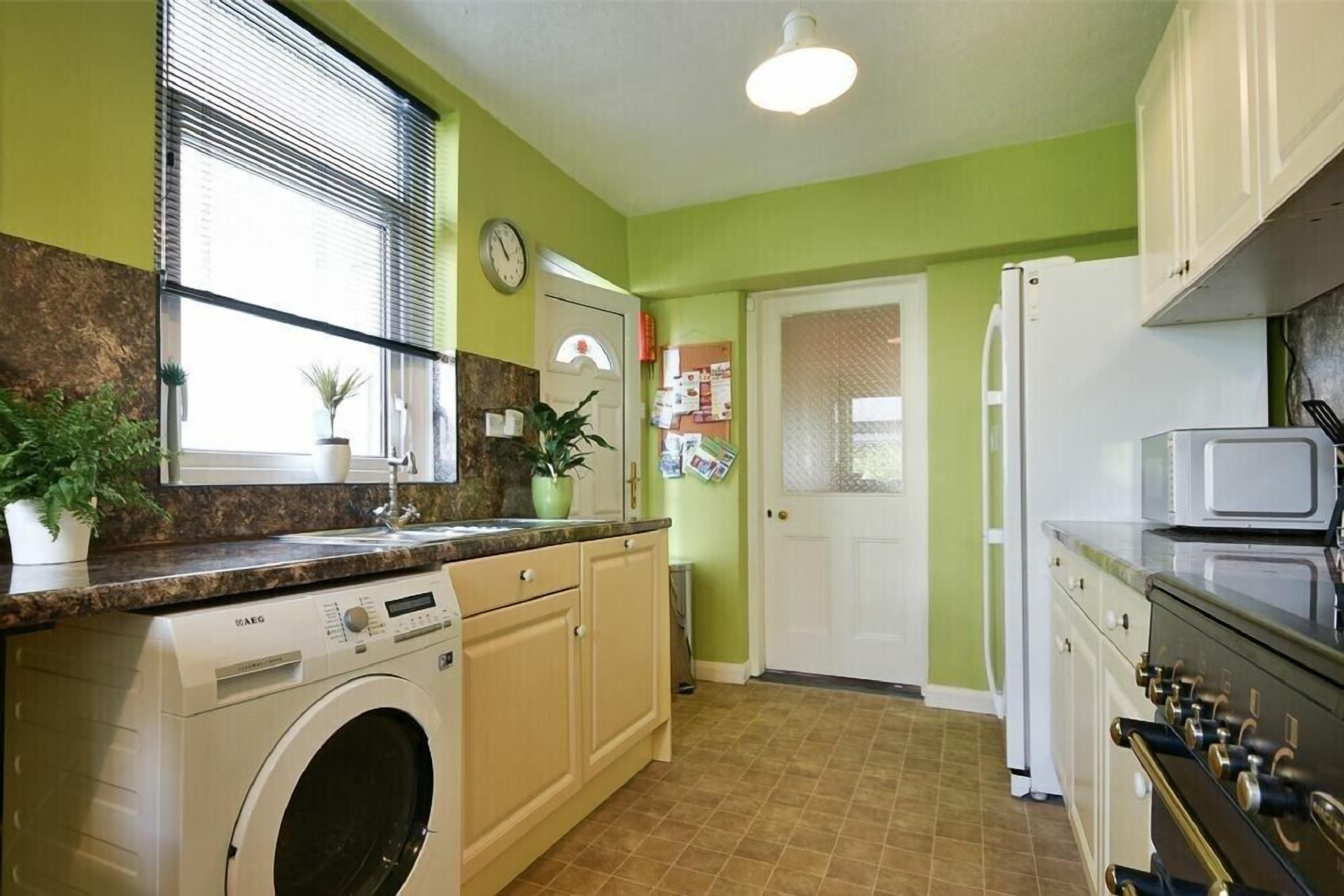 A compact kitchen with a washing machine, a refrigerator, and a stove.