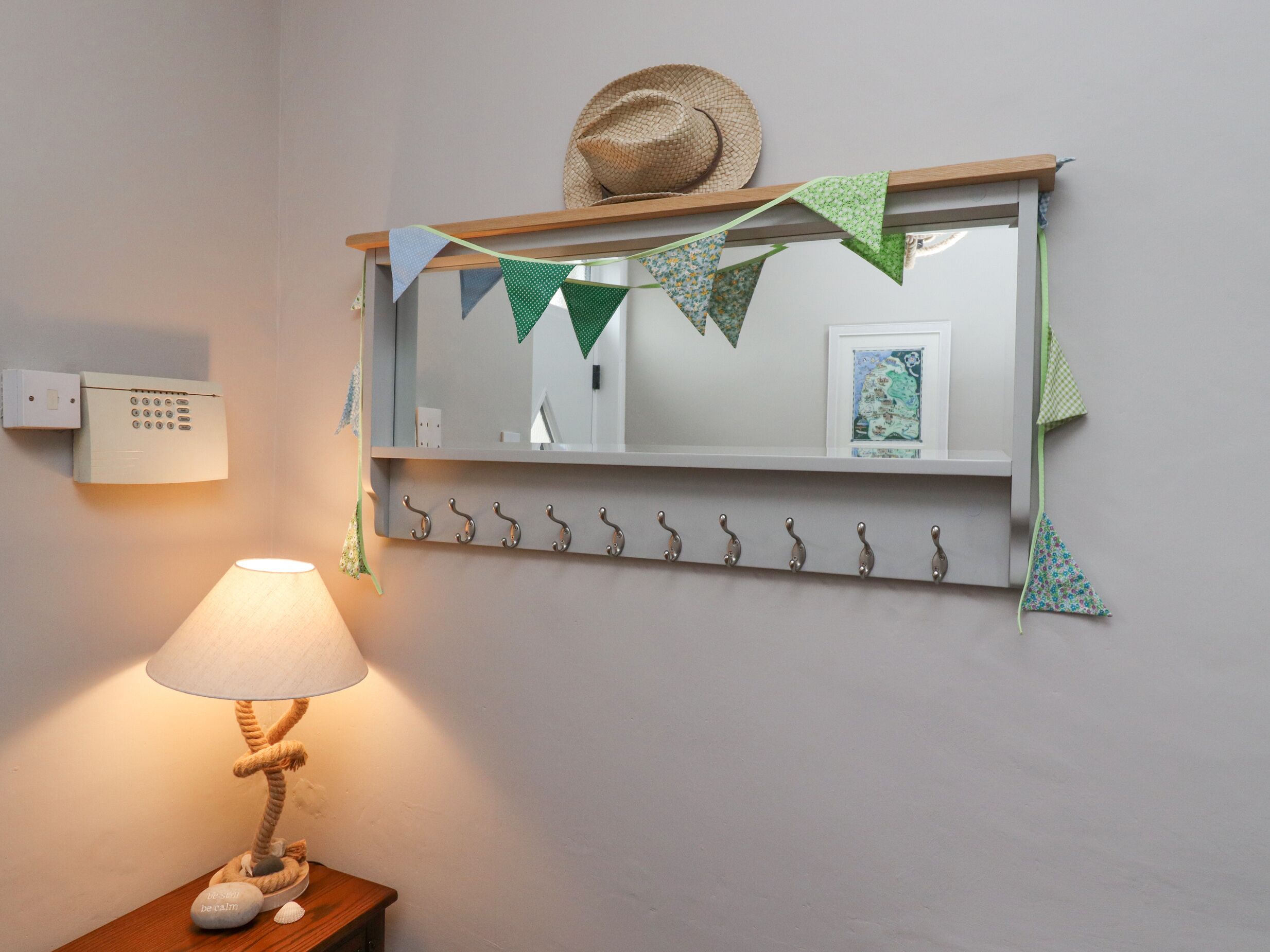 Een badkamer met spiegel, handdoekhouder en lamp.