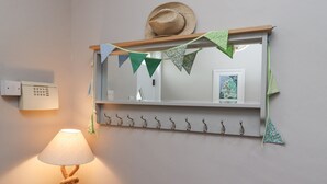 Une salle de bain avec un miroir, un porte-serviettes et une lampe.