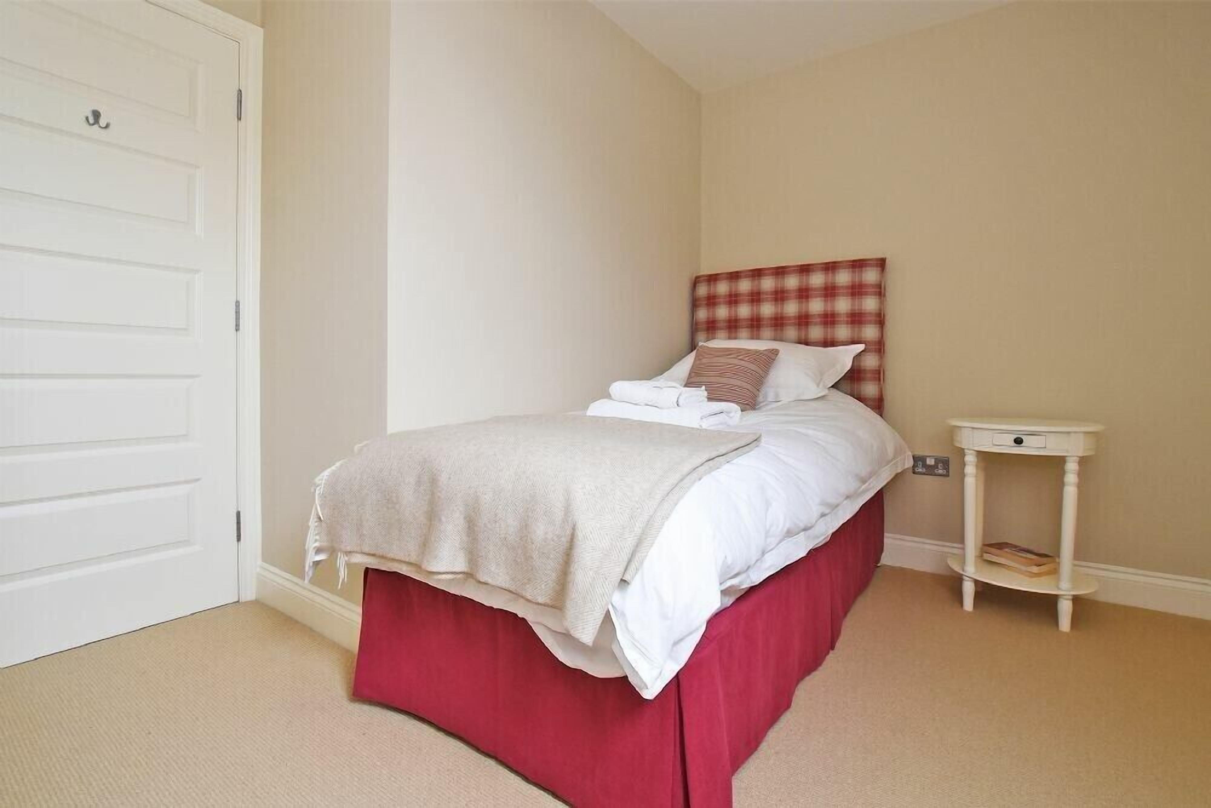 Une chambre à coucher avec un lit, une table de chevet et une porte.