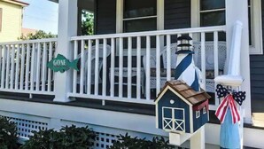 A porch with a white railing, a small blue house decoration, and a 'Gone' sign. - Blue Bay Dream w/ Seasonal Outdoor Jacuzzi, Cabana + Office (Greenport,)