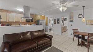 A modern kitchen with wooden cabinets, a central island, and a ceiling fan.