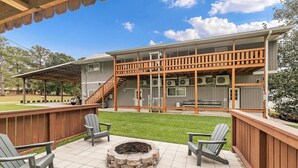A two-story building with a covered patio area, outdoor seating, and a fire pit. - "The Lodge"-  APT w/Loft Bedroom, Walnut Bar, Quiet Setting, Covered Parking (Enterprise)