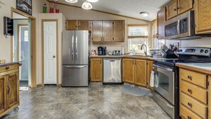 A kitchen with wooden cabinets, stainless steel appliances, and a tiled floor. - Sevierville Home: Lookout Deck, 10 Mi to Dollywood (Sevierville)