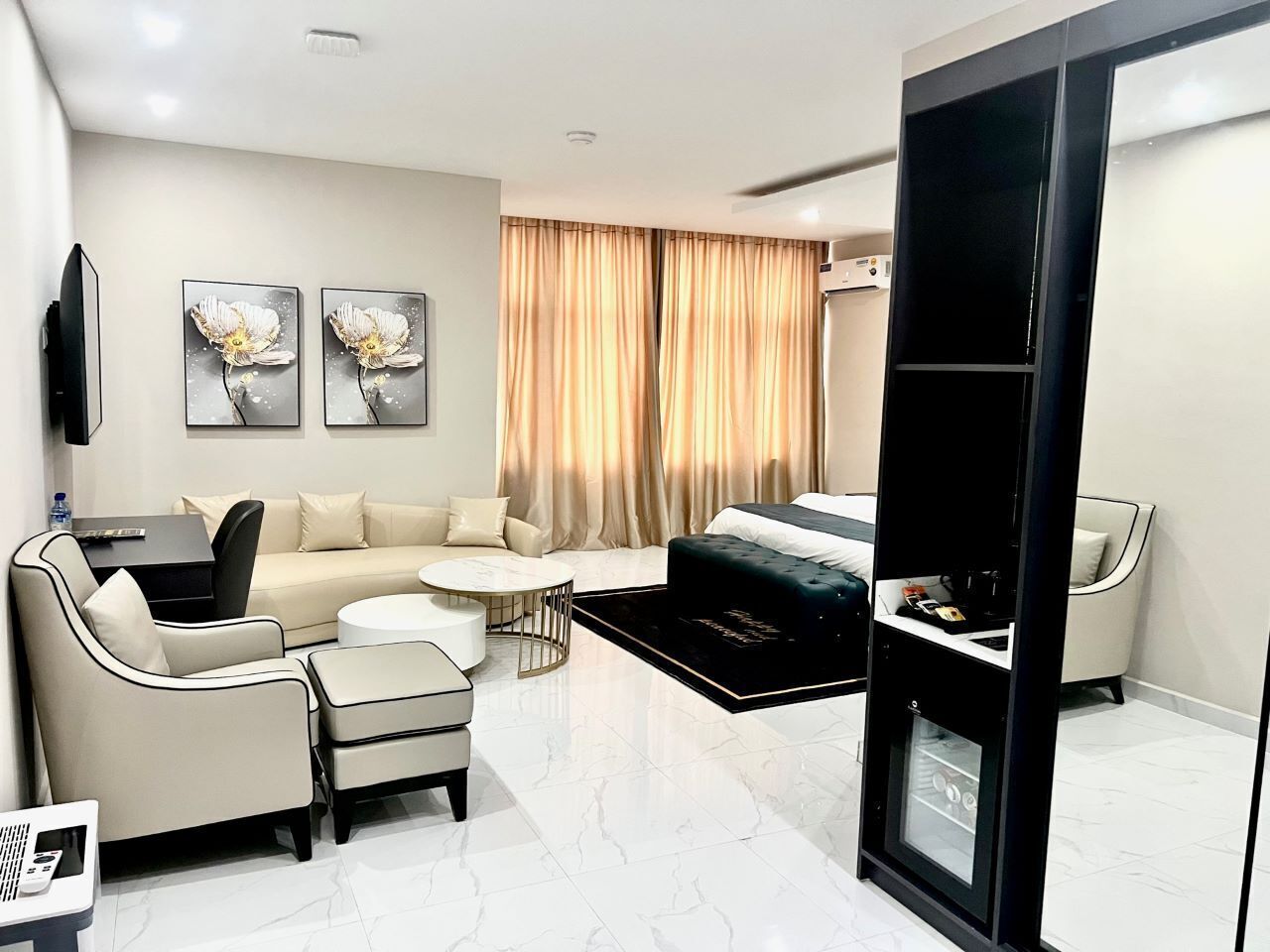 Una sala de estar moderna con un sofá, sillones, una mesa de centro y un televisor.