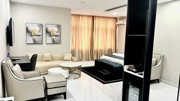 Una sala de estar moderna con un sofá, sillones, una mesa de centro y un televisor.