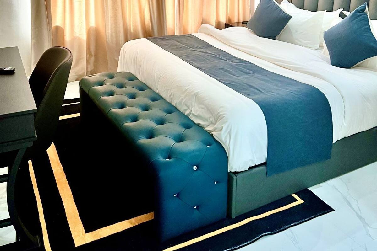 Een hotelkamer met een groot bed, een bureau en een stoel.