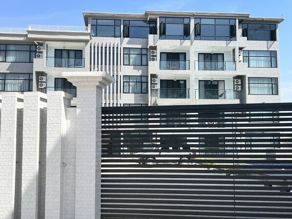 Um edifício moderno de vários andares, com grandes janelas e aparelhos de ar condicionado.