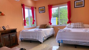 A hotel room with two beds, a wooden cabinet, and a window with red curtains. - Hotel EbenEzer El Paredon (Sipacate)