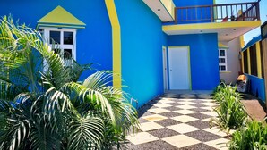 A brightly colored building with a blue and yellow facade, a checkered entrance, and a balcony. - Hotel EbenEzer El Paredon (Sipacate)