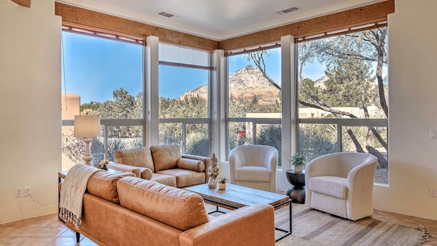 A spacious living room with a large window offering a view of a mountainous landscape. - Red Rock Mtn View & Fire Pit: Central Sedona Home! (Sedona)