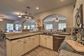 A spacious kitchen with granite countertops, wooden cabinets, and a central island. - Lavish Family Escape w/ Game Room in Avondale! (Avondale)
