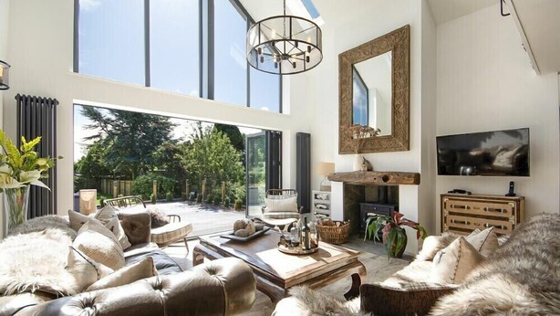 A spacious living room with a large window, a fireplace, and a television. - Marmalade Cottage (Seahouses)