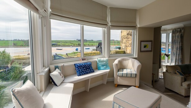 A room with a large window, a sofa, a chair, and a small table. - The Beach House, Alnmouth (Alnwick)