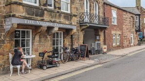 A stone building with a sign reading "The Village Tearooms". - Five Bells Cottage (Alnwick)