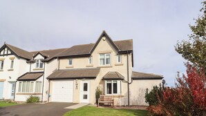A two-story residential building with a front driveway, a small porch, and a well-maintained lawn. - Beach View (Seahouses)