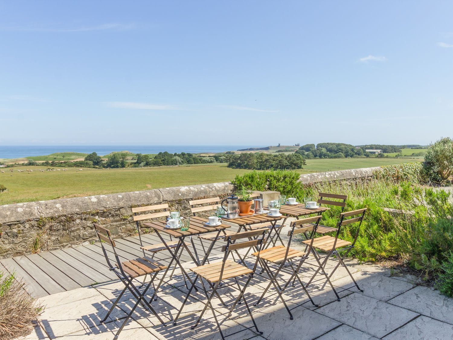 An outdoor seating area with tables and chairs overlooking a scenic landscape.