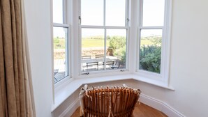 Ein Zimmer mit großem Erkerfenster mit Blick auf einen Garten.