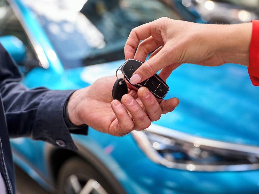 Una persona entregando las llaves de un coche a otra.