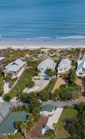 An aerial view of a coastal residential area with houses, a beach, and a boardwalk. - Array of Sunshine Beach House (St. Augustine)
