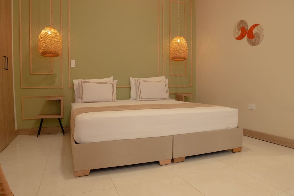 Ein Schlafzimmer mit einem großen Bett, zwei Nachttischen und zwei Wandlampen.