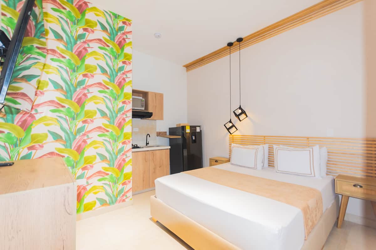 Ein modernes Hotelzimmer mit einem Bett, einem Nachttisch und einem kleinen Holzbeistelltisch.