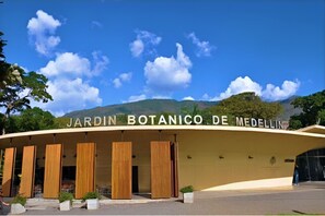 Un bâtiment moderne à la façade incurvée, sur lequel on peut lire l’inscription « JARDIN BOTANIQUE DE MEDELLÍN ».