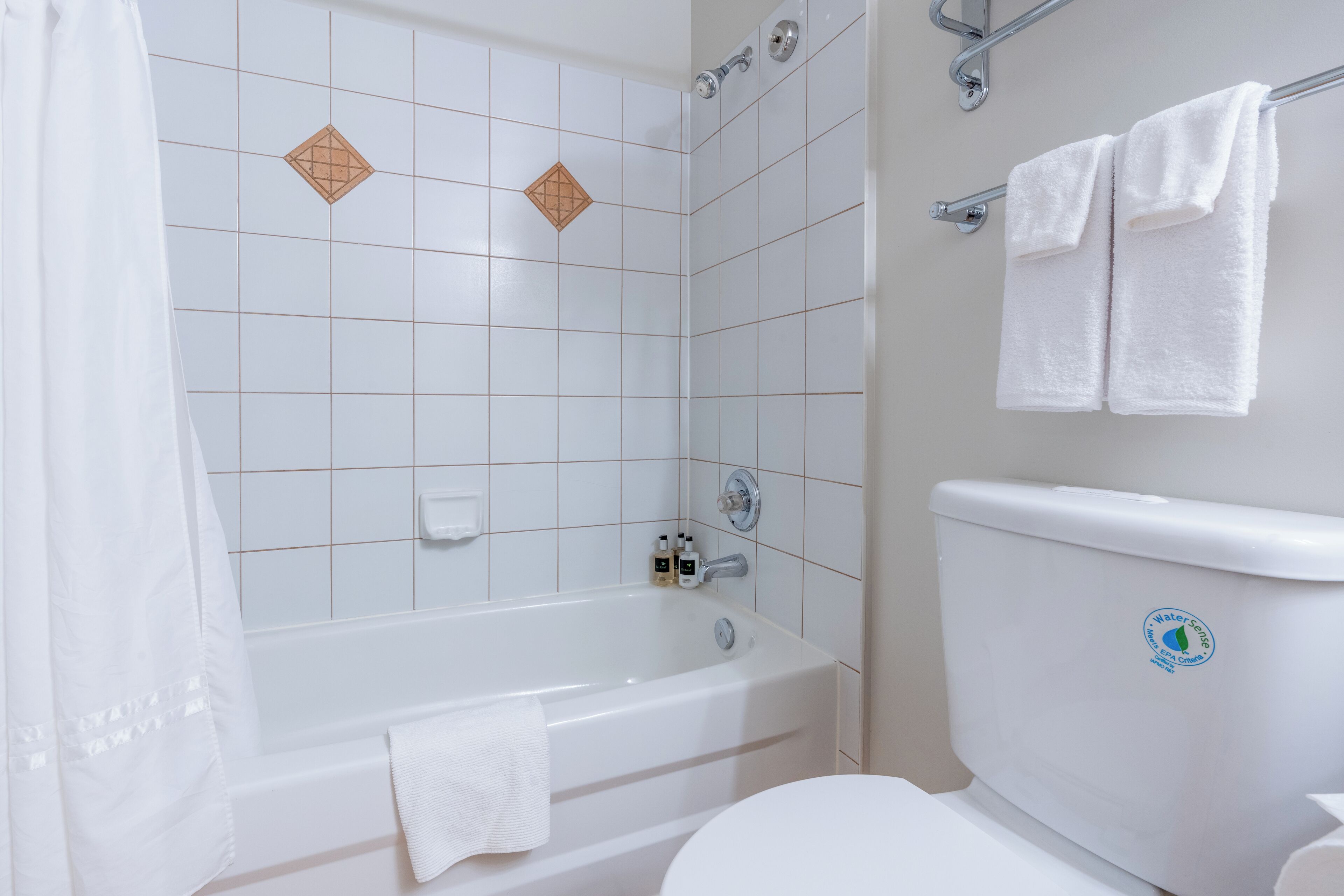 A bathroom with a bathtub, toilet, and a shower area.