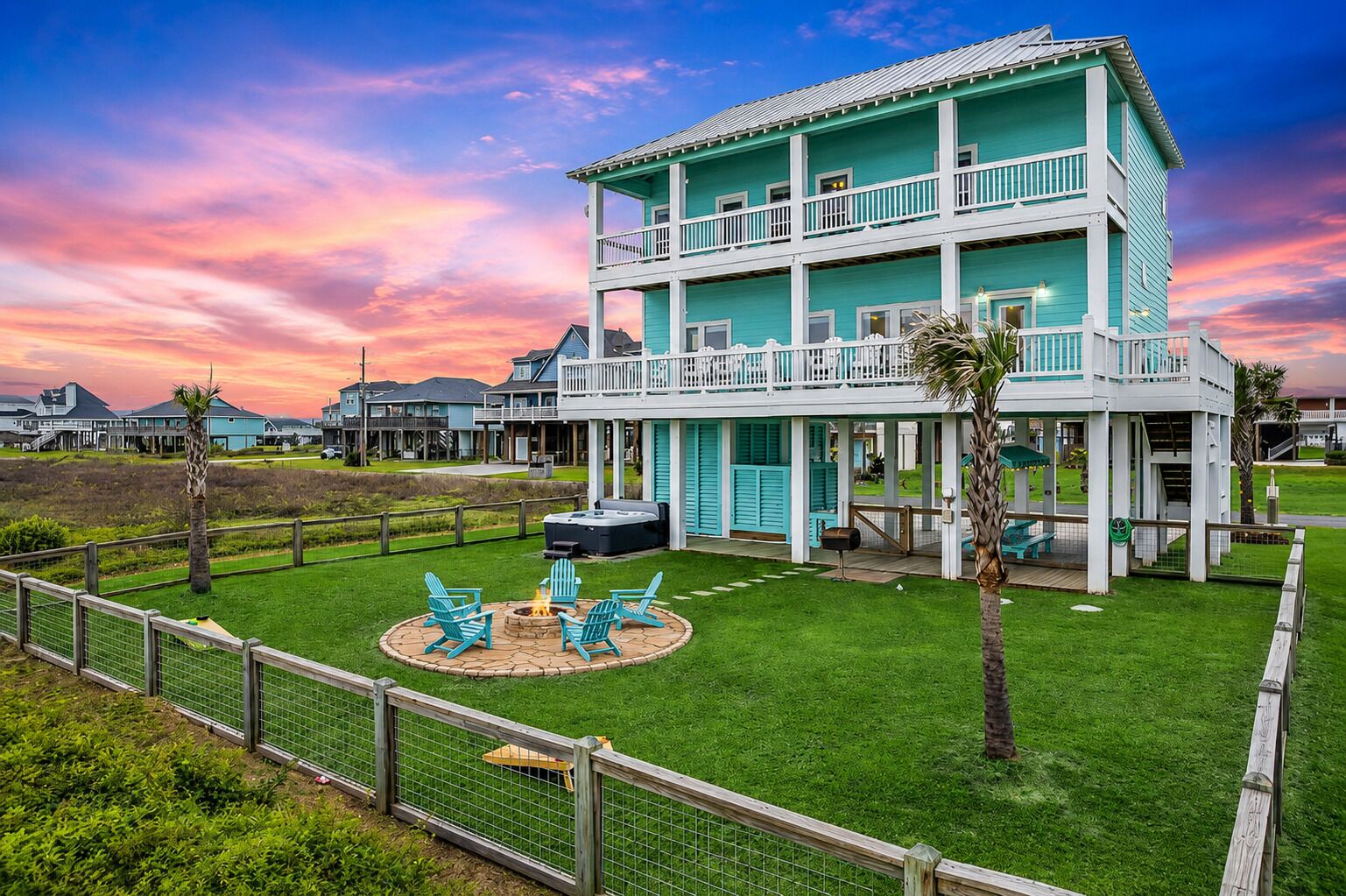 A two-story building with a balcony, a fire pit, and outdoor seating.