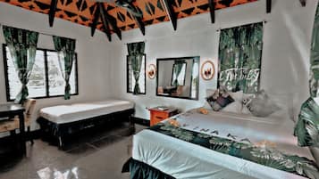 A bedroom with a bed, a desk, a chair, a ceiling fan, and a window with curtains.