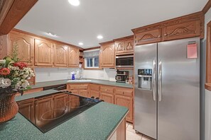 Enjoy cooking in this kitchen with a classic design, featuring a refrigerator, microwave, induction cooktop, and ample counter space.