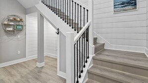 Una escalera con barandillas blancas y piso de madera.