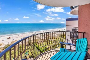 A balcony with a view of a beach and ocean.