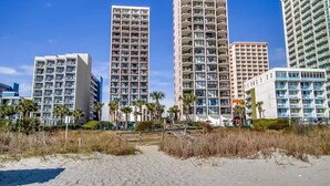 A beachfront hotel with multiple high-rise buildings, a sandy beach, and palm trees. - On the Beach w/Direct Ocean Views & Beach Access within steps! RENOVATED (Myrtle Beach)