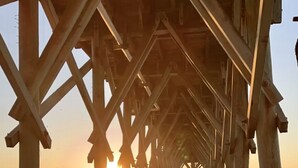 A wooden pier extending into the sea with the sun setting in the background. - On the Beach w/Direct Ocean Views & Beach Access within steps! RENOVATED (Myrtle Beach)