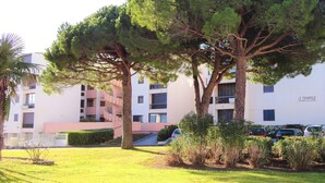 A building with multiple balconies and a sign that reads "LE TRIANGLE BARONNIE DE LA MER". - Fully equipped cabin studio 4 people parking (LE GRAU DU ROI)
