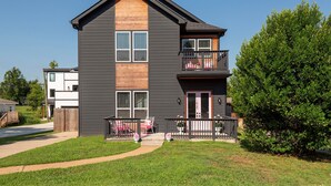 A two-story building with a dark exterior, a wooden accent wall, and a balcony with a railing. - Lipstick n Legends 2 Miles Downtown, Hot Tub, Pool (Nashville)