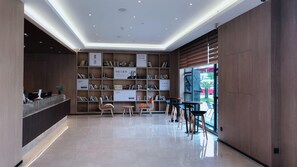 Uma biblioteca moderna com estantes, balcão de atendimento e áreas de estar.