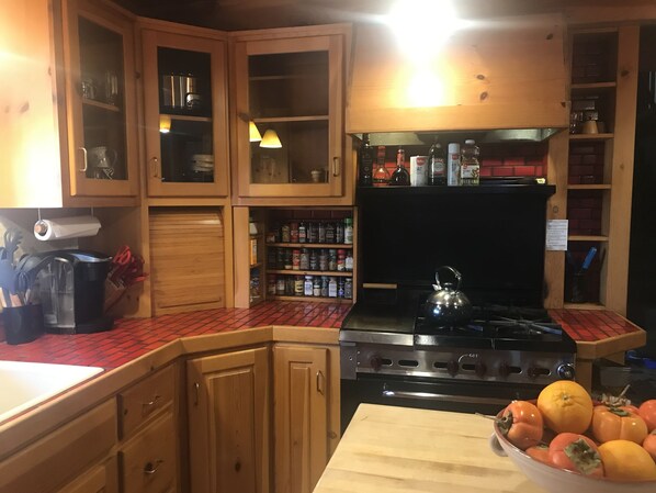 Una cocina con armarios de madera, una estufa y un tazón de fruta sobre la encimera.