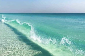 A beach with clear turquoise water and gentle waves. - A+ Location across from beach. Free bikes & beach equipment! (Santa Rosa Beach)